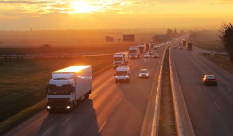 Image of vehicles on a highway at sunset to portray the transportation industry