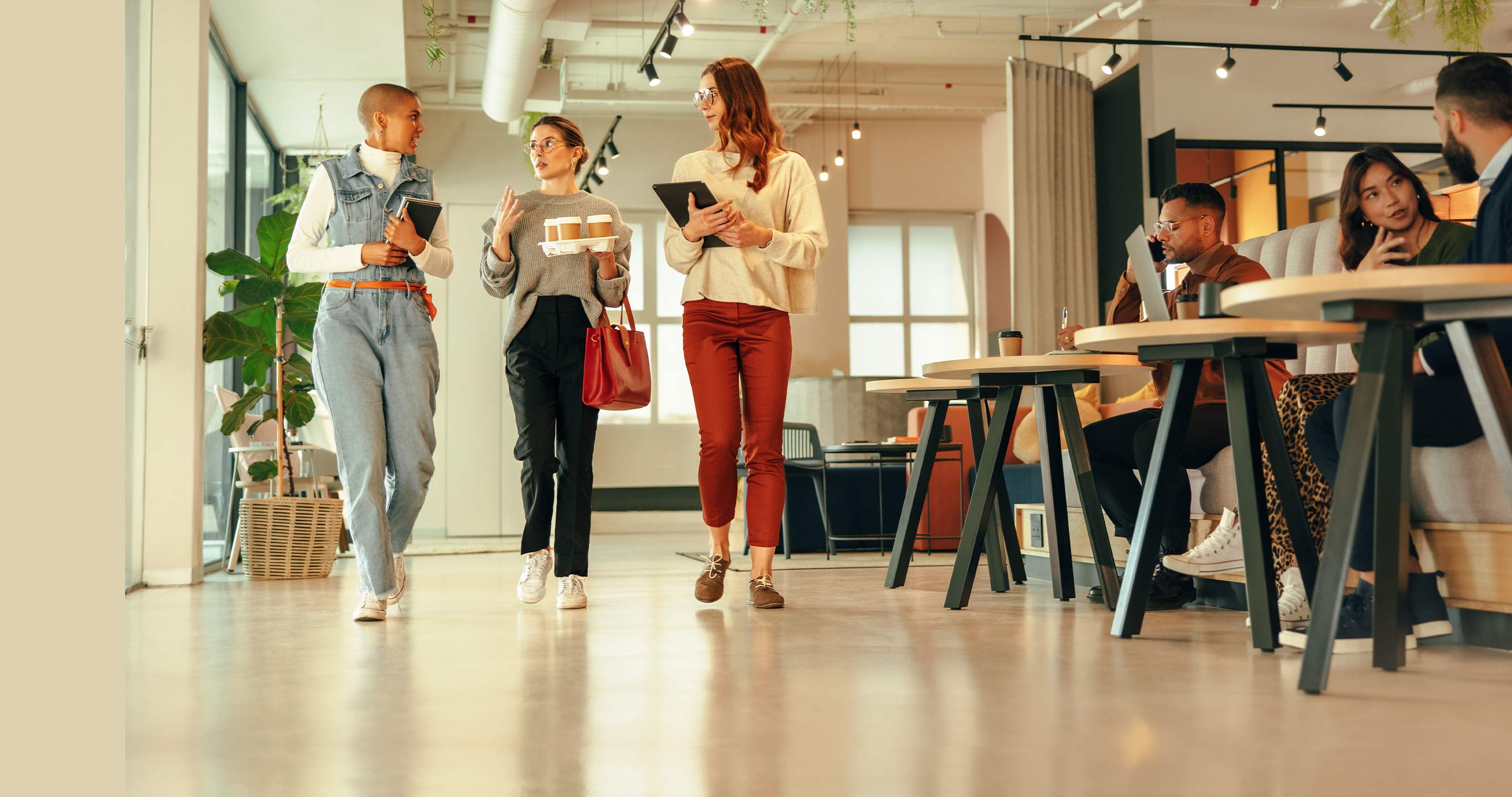 Middle aged female product manager walking and discussing with diverse team members in a modern office