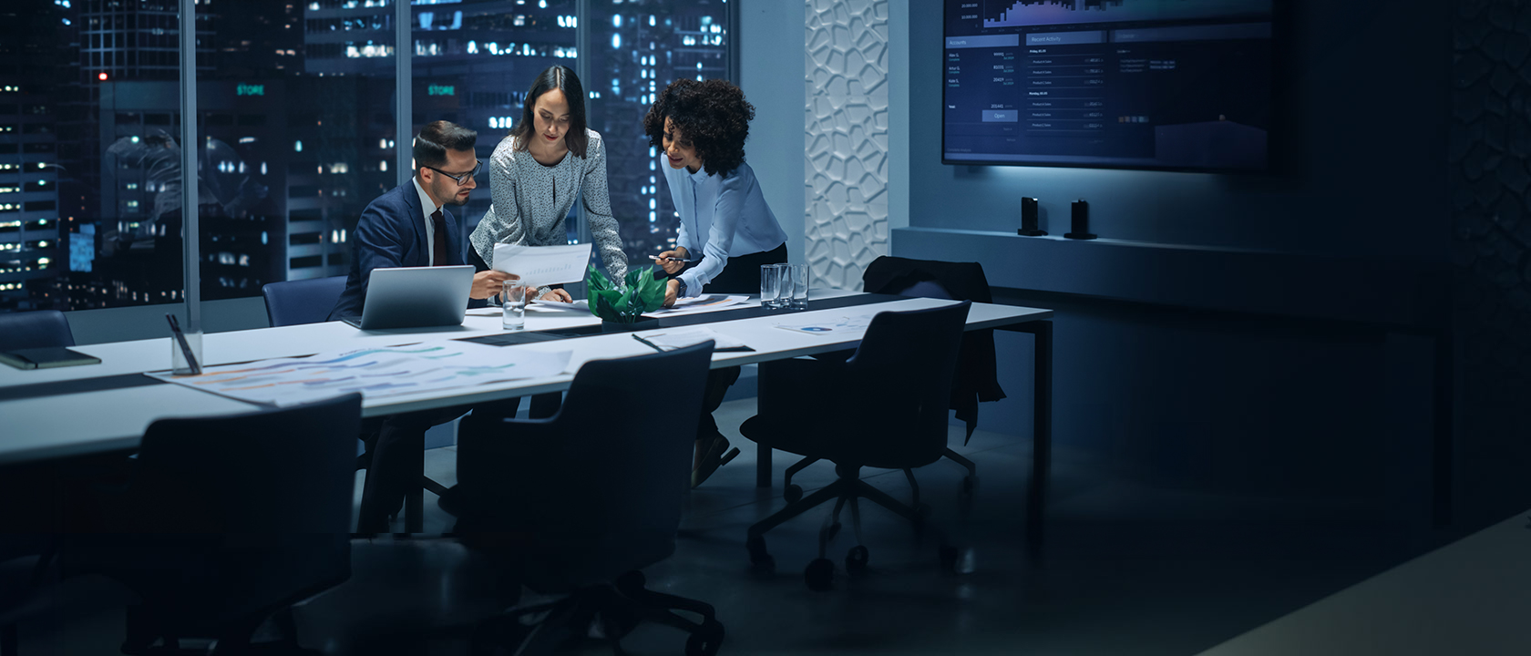 Team of product managers reviewing a product strategy in office at night