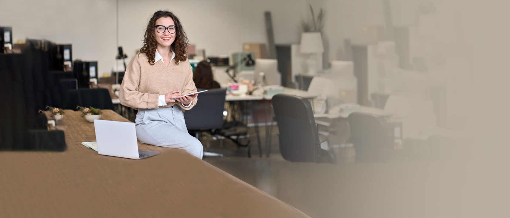 Female digital marketing professional working on a tablet in a modern office setting