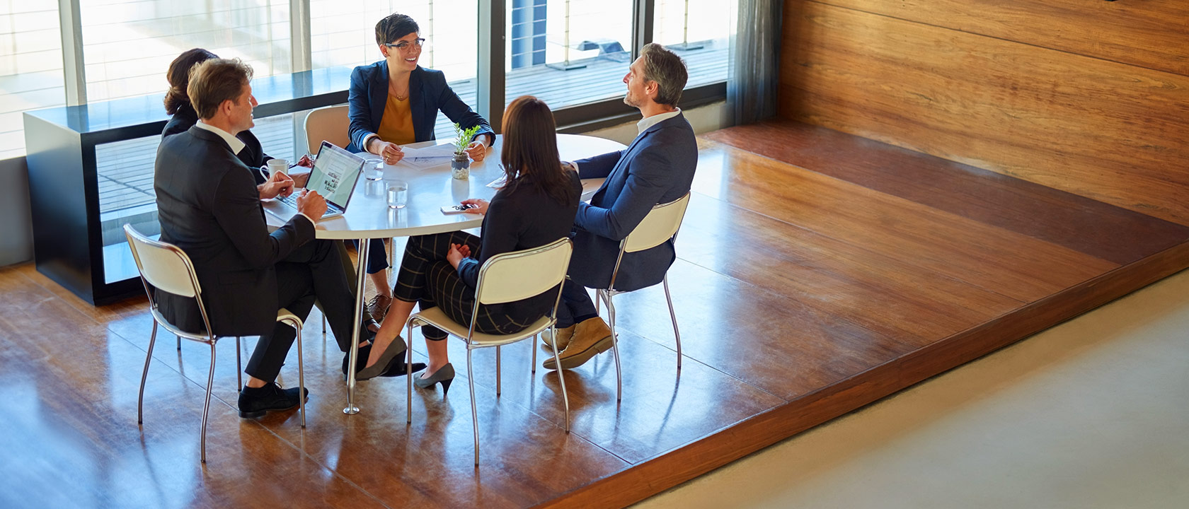 Multi-gender managers discussing business in a board room